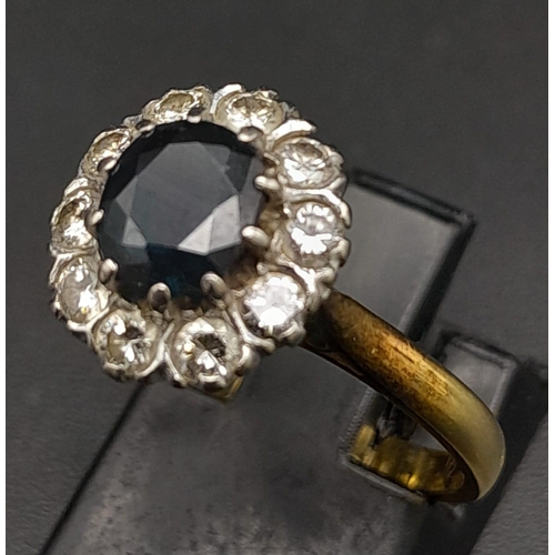 156 - An 18K Yellow Gold Diamond and Sapphire Ring. Central oval sapphire surrounded by a halo of diamonds... 