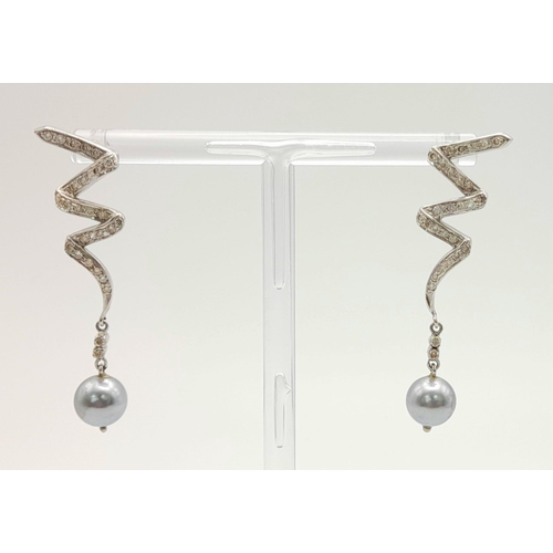 163 - A Pair of Platinum, Diamond and Tahitian Pearl Swirl Drop Earrings. 4cm drop. No earring backs. 6.4g... 