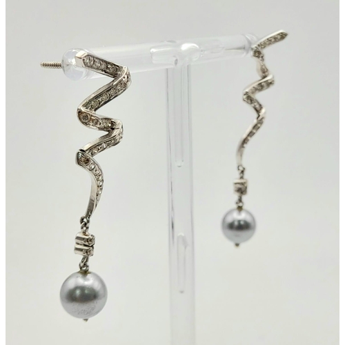 163 - A Pair of Platinum, Diamond and Tahitian Pearl Swirl Drop Earrings. 4cm drop. No earring backs. 6.4g... 