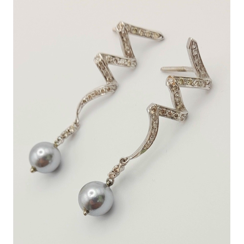 163 - A Pair of Platinum, Diamond and Tahitian Pearl Swirl Drop Earrings. 4cm drop. No earring backs. 6.4g... 