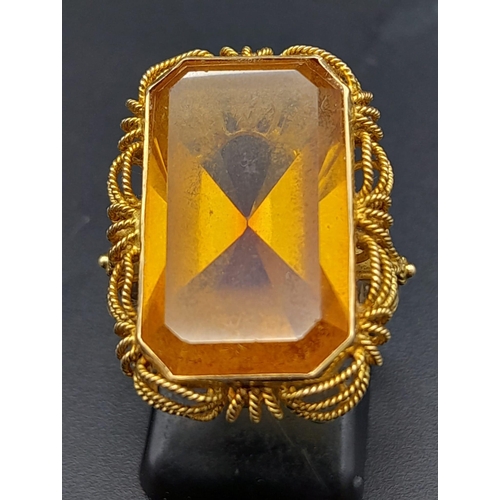 218 - A Vintage 14K Yellow Gold Citrine Ring. Large rectangular cut citrine in a decorative scroll setting... 