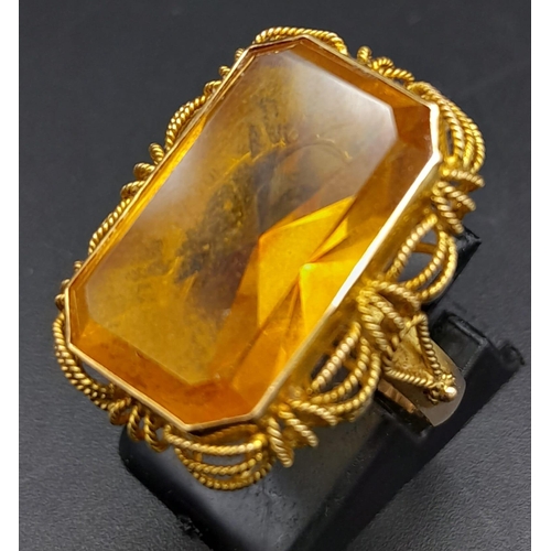 218 - A Vintage 14K Yellow Gold Citrine Ring. Large rectangular cut citrine in a decorative scroll setting... 