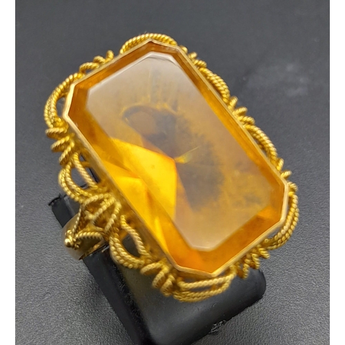 218 - A Vintage 14K Yellow Gold Citrine Ring. Large rectangular cut citrine in a decorative scroll setting... 