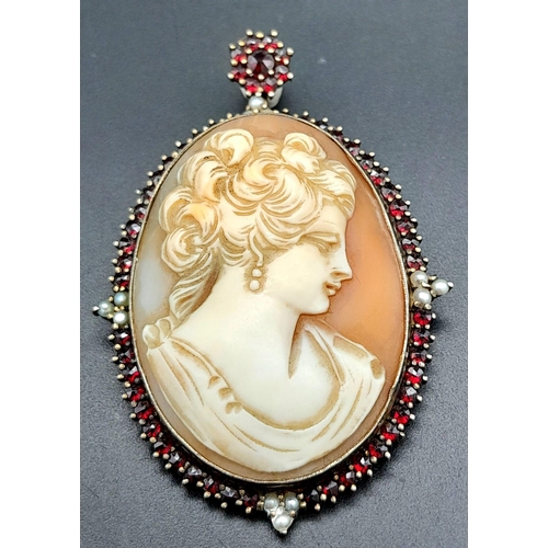 278 - An Antique Cameo Brooch. Decorated with garnet and seed pearls and set in gilded metal. 6cm. 18.24g ... 