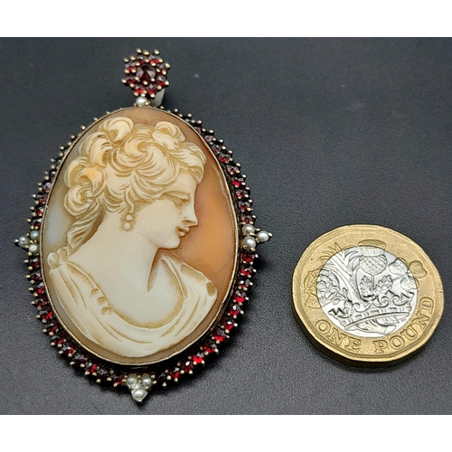 278 - An Antique Cameo Brooch. Decorated with garnet and seed pearls and set in gilded metal. 6cm. 18.24g ... 