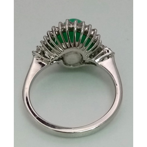 43 - An 18K White Gold, Diamond and Jade Cabochon Ring. A beautiful pale green jade cabochon with a diamo... 