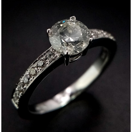 285 - An 18 K white gold ring with beautiful brilliant cut diamond and more diamonds on the shoulders (tot... 