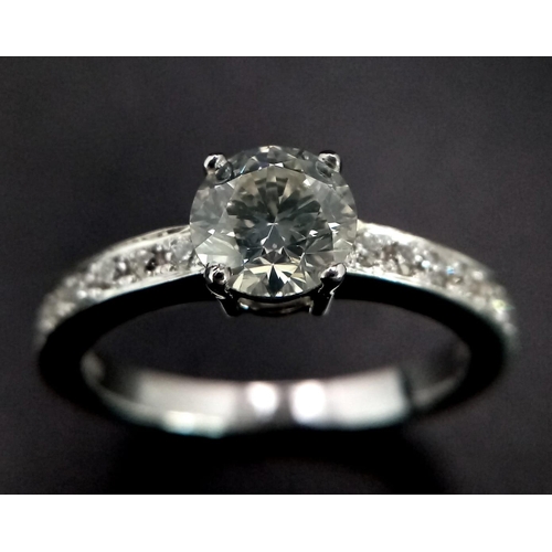 285 - An 18 K white gold ring with beautiful brilliant cut diamond and more diamonds on the shoulders (tot... 