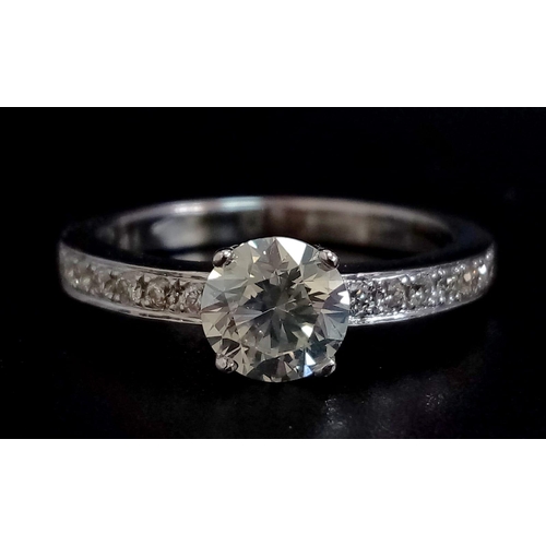 285 - An 18 K white gold ring with beautiful brilliant cut diamond and more diamonds on the shoulders (tot... 