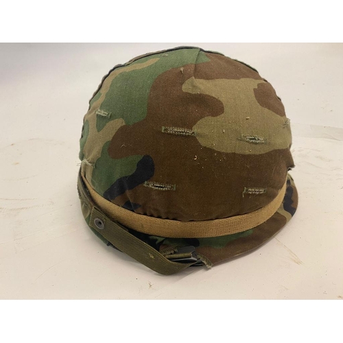 295 - A USA M1 Helmet with a Woodland Camo Cover. The liner is dated 1988 and the cover dated 1984. Ref: M... 