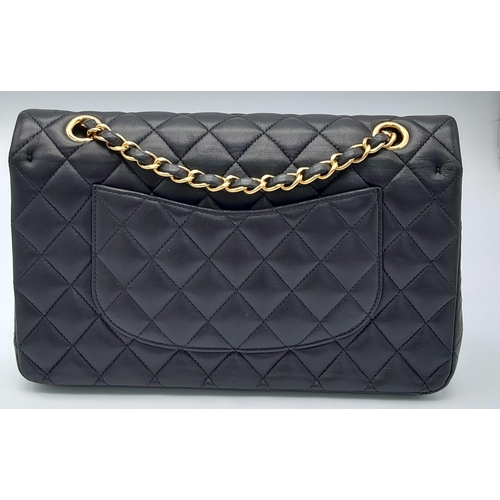 16 - A Classic Chanel Double Flap Bag. Quilted lambskin black leather exterior with gilded Chanel logo cl... 