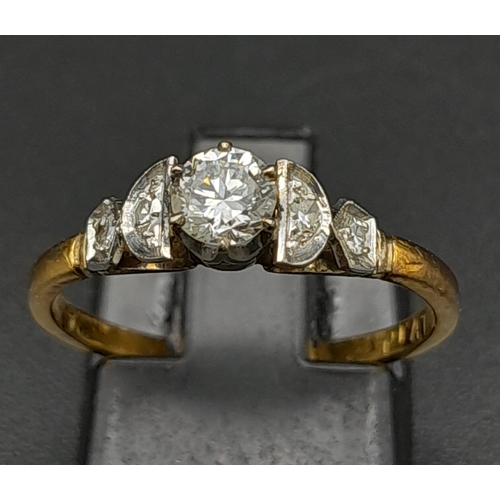 12 - An 18K Yellow Gold Diamond Ring. Central brilliant round cut diamond with two round cut diamonds on ... 