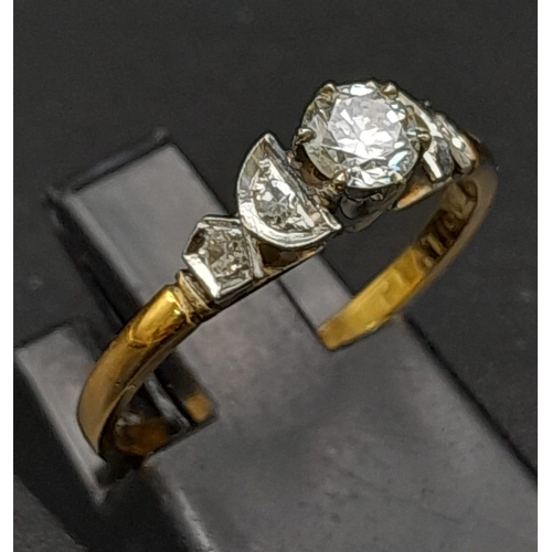 12 - An 18K Yellow Gold Diamond Ring. Central brilliant round cut diamond with two round cut diamonds on ... 