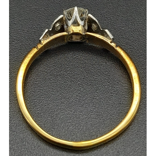 12 - An 18K Yellow Gold Diamond Ring. Central brilliant round cut diamond with two round cut diamonds on ... 