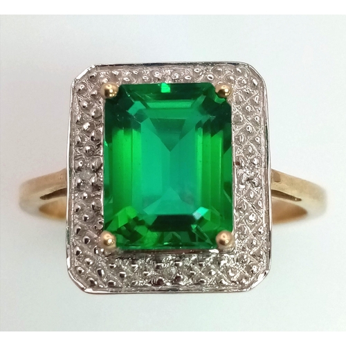 167 - A 9 K yellow and white gold ring with an emerald cut synthetic, flawless emerald. Fully British hall... 