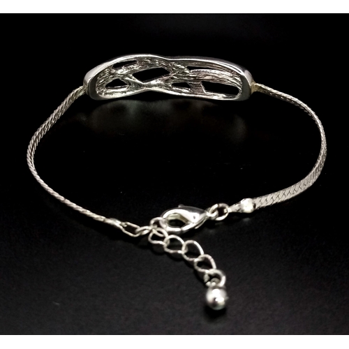 797 - A very elegant, sterling silver bracelet with an eternity knot studded with clear stones. Weight: 7.... 