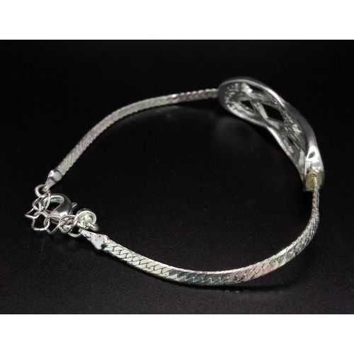 797 - A very elegant, sterling silver bracelet with an eternity knot studded with clear stones. Weight: 7.... 