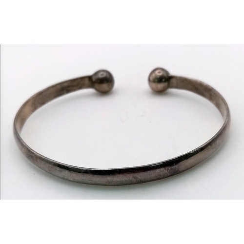 917 - A sterling silver bangle with round balls at each end perfect for pain relief from athritis. Weight:... 