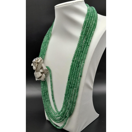 146 - An impressive, six row necklace with faceted emerald beads and highly ornamental, white metal (untes... 