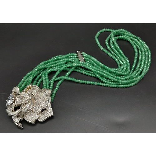 146 - An impressive, six row necklace with faceted emerald beads and highly ornamental, white metal (untes... 