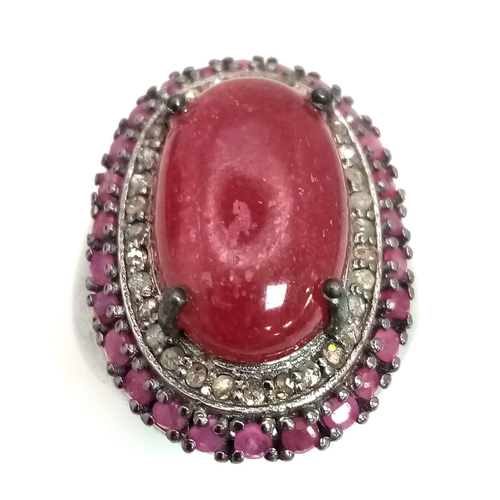 60 - An 11.45cts Cabochon Ruby Ring with .45ct Diamond and 1.25ct Ruby halos. Set in 925 silver. Size N. ... 