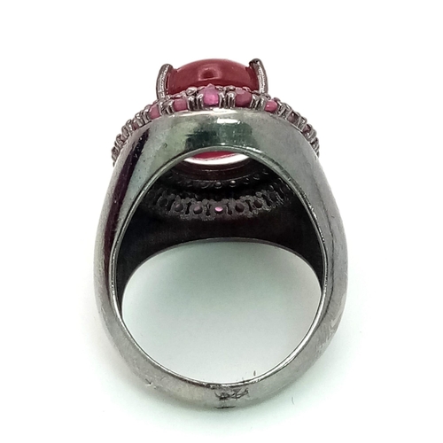 60 - An 11.45cts Cabochon Ruby Ring with .45ct Diamond and 1.25ct Ruby halos. Set in 925 silver. Size N. ... 