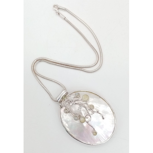 818 - A sterling silver snake chain with a very unusual large pendant made with Mother of Pearl and decora... 