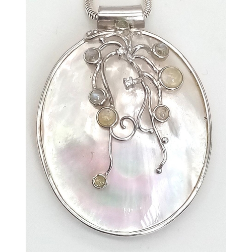 818 - A sterling silver snake chain with a very unusual large pendant made with Mother of Pearl and decora... 