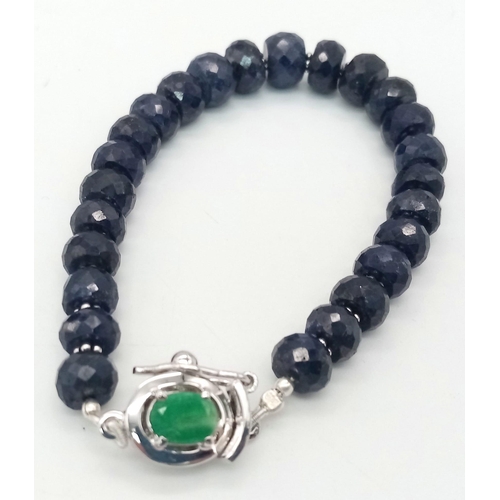 360 - A 140ct Blue Sapphire Rondelle Bracelet with Emerald and 925 Silver Clasp. 17cm.