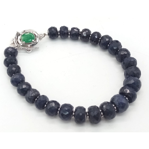 360 - A 140ct Blue Sapphire Rondelle Bracelet with Emerald and 925 Silver Clasp. 17cm.