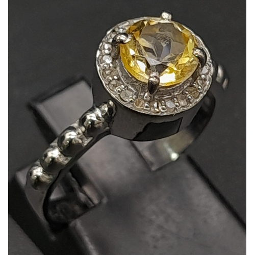 422 - A Citrine and Rose-Cut Diamond Ring. Central citrine stone with rose-cut diamond halo and wings. Set... 