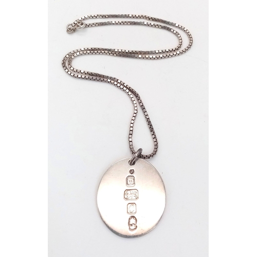 825 - A sterling silver chain necklace with a large round flat pendant carrying oversized British hallmark... 