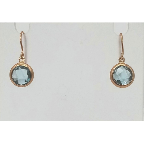 757 - A Pair of 9K Yellow Gold Blue Topaz Earrings. Faceted topaz circles. 1.46g total weight.