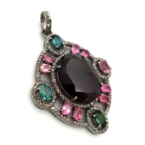 128 - A Ruby & Tourmaline Silver Pendant. Large oval ruby with a two colour tourmaline surround. Finished ... 