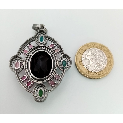 128 - A Ruby & Tourmaline Silver Pendant. Large oval ruby with a two colour tourmaline surround. Finished ... 