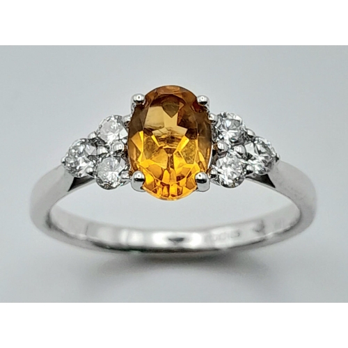 131 - An 18K White Gold, Citrine and Diamond Ring. Oval cut citrine with three bright white round cut diam... 