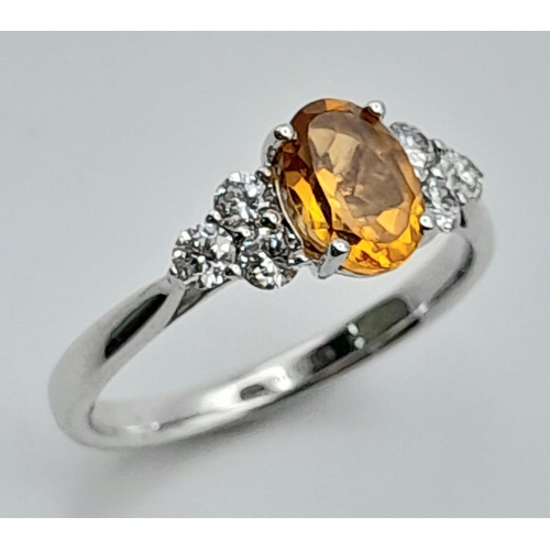 131 - An 18K White Gold, Citrine and Diamond Ring. Oval cut citrine with three bright white round cut diam... 