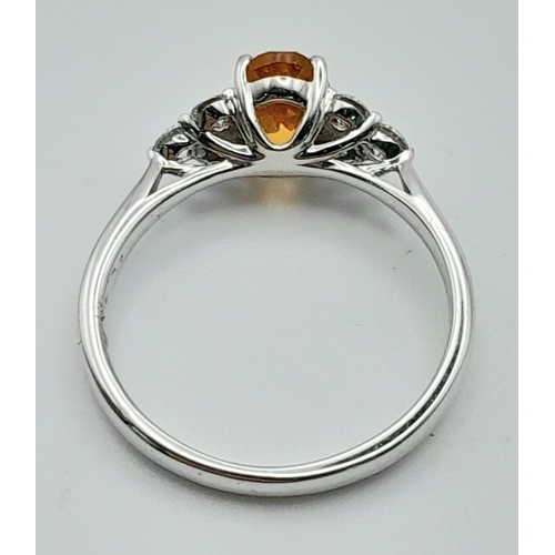 131 - An 18K White Gold, Citrine and Diamond Ring. Oval cut citrine with three bright white round cut diam... 