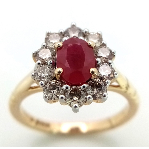 324 - A 9K yellow gold ring set with oval ruby and a halo of round brilliant cut diamonds. Ruby - 1.00ct. ... 