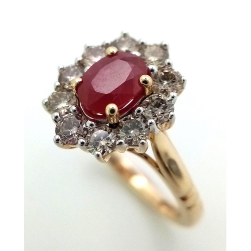 324 - A 9K yellow gold ring set with oval ruby and a halo of round brilliant cut diamonds. Ruby - 1.00ct. ... 