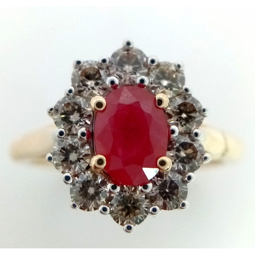 324 - A 9K yellow gold ring set with oval ruby and a halo of round brilliant cut diamonds. Ruby - 1.00ct. ... 