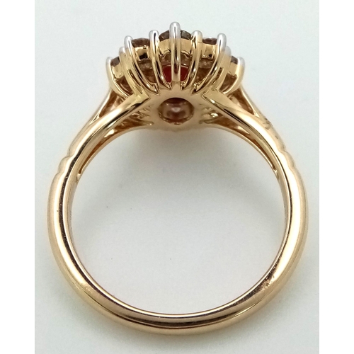 324 - A 9K yellow gold ring set with oval ruby and a halo of round brilliant cut diamonds. Ruby - 1.00ct. ... 