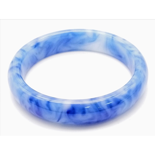 375 - A Rippled Blue and White Jade Bangle. 6cm inner diameter. 14mm width.