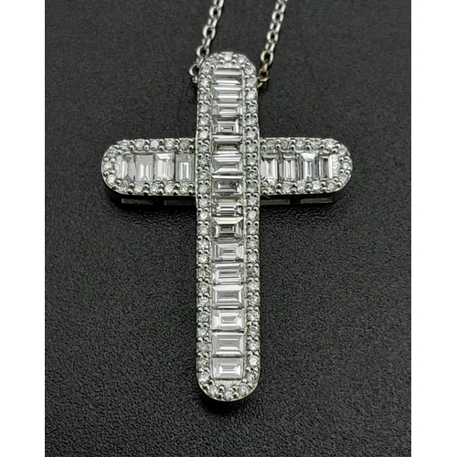 443 - An 18K white gold baguette-cut diamond cross with round brilliant cut diamond set edges on an 18K wh... 