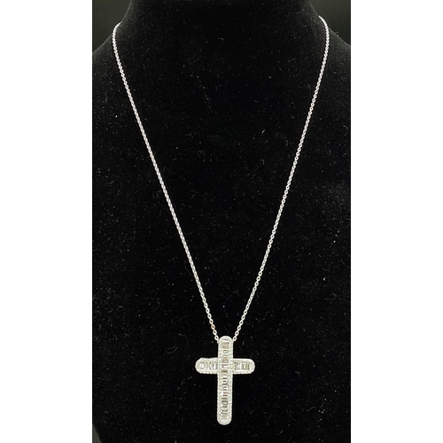 443 - An 18K white gold baguette-cut diamond cross with round brilliant cut diamond set edges on an 18K wh... 