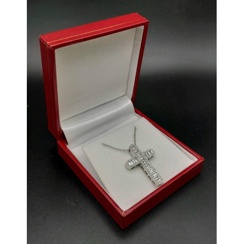 443 - An 18K white gold baguette-cut diamond cross with round brilliant cut diamond set edges on an 18K wh... 