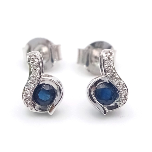 694 - A Pair of 9K White Gold, Sapphire and Diamond Swirl Earrings. 1.45g total weight.