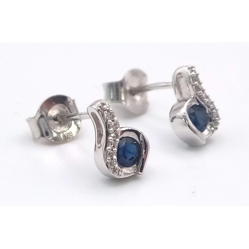 694 - A Pair of 9K White Gold, Sapphire and Diamond Swirl Earrings. 1.45g total weight.