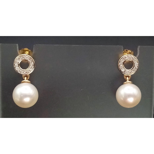 774 - A pair of 9K yellow gold cultured pearl droplet earrings with diamond halo bales. 0.15ct. Boxed. Ref... 