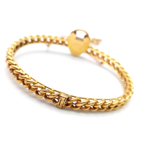 82 - AN ANTIQUE 15K GOLD LINK BANGLE WITH HEART PADLOCK , KEY AND SAFETY CHAIN .  12.9gms